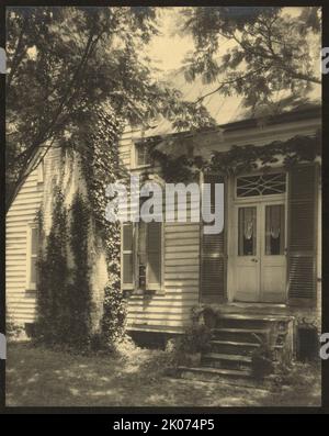 M. Eddy Brooks, extérieur de la maison, entre 1925 et 1929. La photo montre une vue extérieure d'un petit chalet en briques et panneaux de claapboard avec portes et cheminée couverte de lierre, Falmouth, Virginie. Banque D'Images