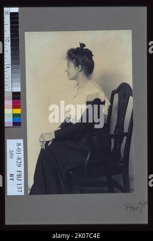 Portrait de profil d'une femme assise sur une chaise, face à gauche, les mains sur les genoux, C1900. Banque D'Images