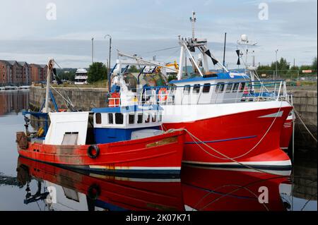 Chalutier pêchant en bateau rouge au port de Peterhead en Écosse Banque D'Images