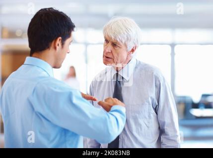 Les doutes des entreprises. Portrait d'un jeune cadre qui dissipe ses doutes d'affaires avec un homme d'affaires senior. Banque D'Images