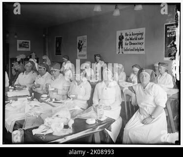 Dressing chirurgical de Mme Blair, entre 1910 et 1920. Femmes en uniforme de la Croix-Rouge préparant des bandages. Affiches sur le mur lire: 'Gee!! J'aurais bien voulu être un homme - je me joins à la Marine - être un homme et le faire - United States Navy Recruiting Station"; "il garde le monde sûr pour la démocratie - s'enrôler et l'aider". Banque D'Images