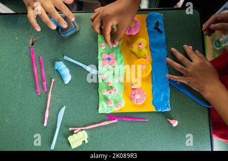 (220910) -- LUDING, le 10 septembre 2022 (Xinhua) -- les enfants de la ville de Detuo font des 'gâteauxs' créatifs avec de la plasticine au refuge de secours au séisme de l'école secondaire Luding no 2 à Luding, dans la province du Sichuan, dans le sud-ouest de la Chine, le 10 septembre 2022. Après un tremblement de terre de magnitude 6,8 qui a secoué le comté de Luding dans la province du Sichuan, dans le sud-ouest de la Chine, lundi, plus de 800 villageois de la ville de Detuo, dont environ 50 enfants, ont été temporairement relogés dans le lycée de Luding no 2. Depuis 6 septembre, 11 enseignants des jardins d'enfants de Luding et 10 étudiants des collèges et du secondaire se sont portés volontaires pour s'occuper de ces questions Banque D'Images