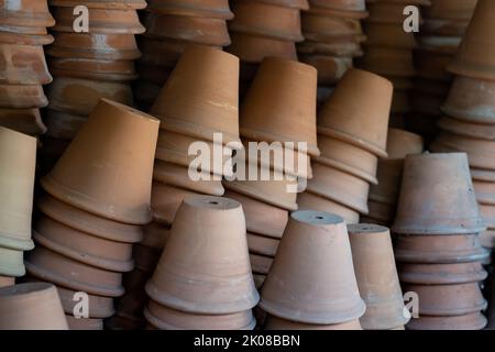 Gros plan des piles de pots de fleurs de terre cuite anciens et altérés dans le hangar de jardinage Banque D'Images