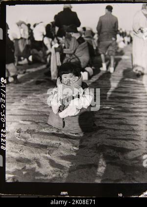 Un petit enfant coréen cherche sa famille comme les réfugiés coréens sans fesses à travers le fleuve Taedong à Pyongyang, en Corée pour échapper aux forces communistes chinoises Banque D'Images