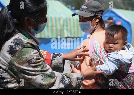 Ya'an, province chinoise du Sichuan. 10th septembre 2022. Un bénévole distribue des gâteaux de lune aux villageois touchés par le tremblement de terre à l'occasion du festival de la mi-automne sur un site de réinstallation dans le comté de Shimian, dans la province du Sichuan, au sud-ouest de la Chine, le 10 septembre 2022. Credit: Liu Qiong/Xinhua/Alay Live News Banque D'Images