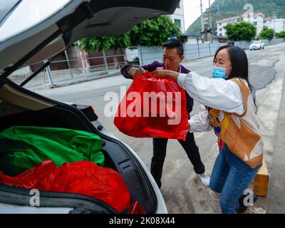 (220910) -- LUDING, 10 septembre 2022 (Xinhua) -- Luo Lian (R) met des articles de papeterie qu'elle a achetés pour les enfants vivant au refuge de secours de séisme à Lengqi ville du comté de Luding, dans le sud-ouest de la province du Sichuan en Chine, le 10 septembre 2022. Luo Lian, 32 ans, est professeur de maternelle dans la ville de Lengqi, dans le comté de Luding. Après un séisme de magnitude 6,8 qui a secoué le comté de Luding, elle s'est portée volontaire pour travailler au refuge de secours aux cake de l'école secondaire de Luding no 2, où plus de 800 villageois, dont environ 50 enfants de la ville de Detuo, l'une des régions les plus touchées, ont été temporairement relocalisés. Avec d'autres bénévoles, Banque D'Images