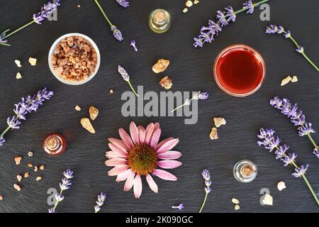 Fond sombre avec des bouteilles d'huile essentielle d'aromathérapie à l'encens, à la myrrhe, à l'échinacée et à la lavande Banque D'Images