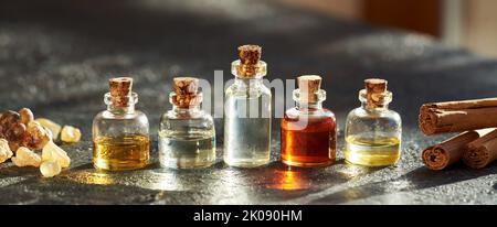 Bouteilles d'huile essentielle d'aromathérapie avec de la résine d'encens et de véritables bâtons de cannelle Banque D'Images