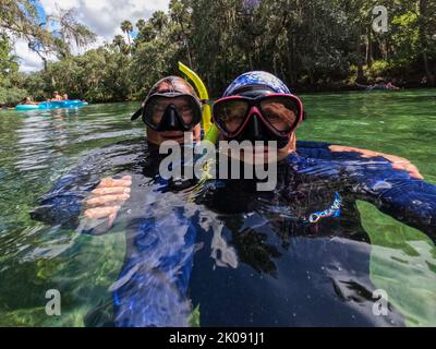 Un couple plongée avec tuba en s'amusant en eau claire en prenant un selfie. Banque D'Images