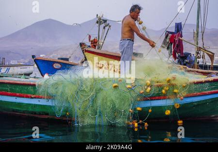 Pêcheurs, bateaux de pêche dans le village de Pucusana sur la côte du Pérou. Banque D'Images