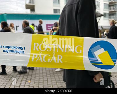 Stockholm, Suède - septembre 10 2022 : signez en suédois avec les informations indiquant que le vote a lieu. En arrière-plan, les personnes en file d'attente vers le bureau de vote. Banque D'Images