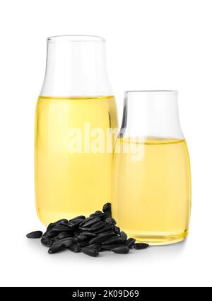 Verres d'huile avec graines de tournesol sur fond blanc Banque D'Images