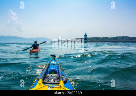 Kayak de mer près de Trwyn du Lighthouse, également connu sous le nom de Penmon Lighthouse au large de Puffin Island, sur la côte d'Anglesey, au pays de Galles au Royaume-Uni Banque D'Images