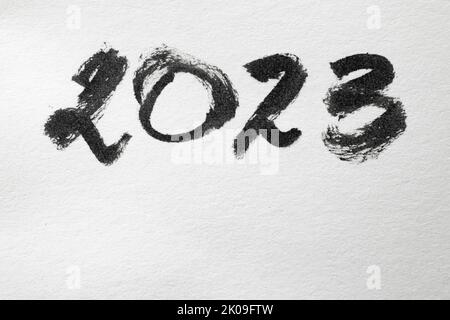 2023 chiffres écrits avec de l'encre noire sur du papier blanc, texture gros plan Banque D'Images