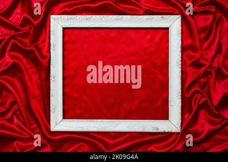 moody photo, d'un vieux cadre en bois blanc sur fond rouge satiné, toile de fond pour la photographie de produit Banque D'Images