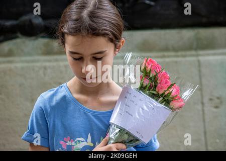 Londres Royaume-Uni 10th septembre 2022 - Une jeune fille, apporte des fleurs avec le message - les amateurs de tournants se rassemblent au Palais de Buckingham en plaçant des fleurs et en payant leur respect - la reine Elizabeth la deuxième est décédée hier dans son année de jubillee platine au château de Balmoral. Photo Horst A. Friedrichs Alamy Live News Banque D'Images