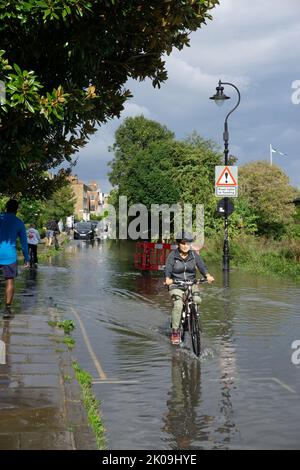 Londres, Angleterre, Royaume-Uni. 10th septembre 2022. Un ciclaste est forcé de monter dans l'eau alors que l'eau inonde la rive de la Tamise à Chiswick, à l'ouest de Londres, après les orages. Cristina Massei/Alamy Live News Banque D'Images