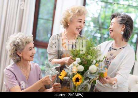 Heureux des amis chinois senior arranger des fleurs ensemble Banque D'Images