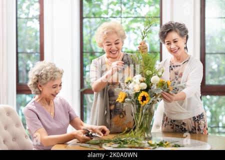 Heureux des amis chinois senior arranger des fleurs ensemble Banque D'Images