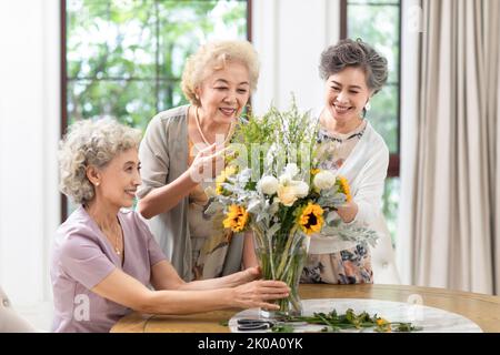 Heureux des amis chinois senior arranger des fleurs ensemble Banque D'Images