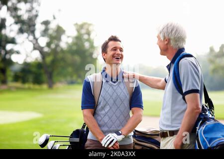 Golfeur masculin en conversation avec son père. Golfeur masculin debout sur le terrain de golf et ayant une conversation avec son père. Banque D'Images