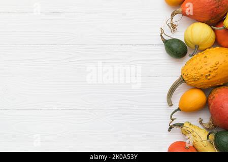 Citrouilles et gourdes décoratives sur fond blanc en bois avec espace de copie pour le texte Banque D'Images