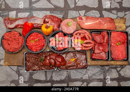 Vue de dessus de coupes de boeuf frais assorties, saucisses et viande hachée isolées sur fond de table en bois Banque D'Images