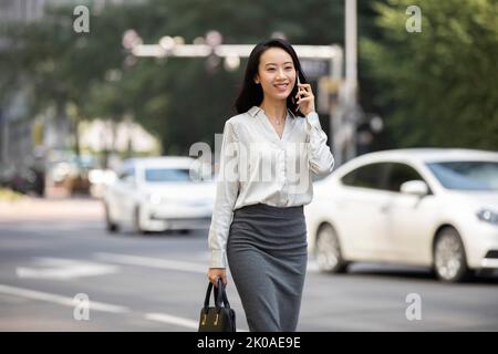 Jeune femme d'affaires chinoise parlant au téléphone Banque D'Images