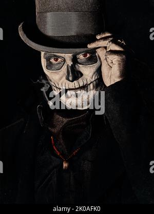 Un jeune homme à l'image du Baron Samedi, la déité Voodoo. Baron samedi vêtu d'un manteau noir et d'un chapeau fumant cigare, portrait en gros plan. Jour du Banque D'Images