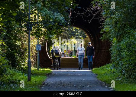 Les gens qui marchent et les cyclistes qui font du vélo à travers le tunnel sur le chemin de fer, Édimbourg, Écosse, Royaume-Uni Banque D'Images