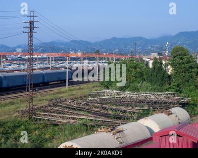 Chemin de fer dans la ville avec la toile de fond des montagnes. Beaucoup de chemins de fer. Wagons et trains sur les voies. Station de déchargement. Wagons-citernes. Batumi. O Banque D'Images