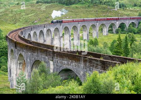 La locomotive à vapeur Jacobite, train touristique, commence à traverser le pont de viaduc emblématique, sur la ligne West Highland, site touristique populaire, due Banque D'Images