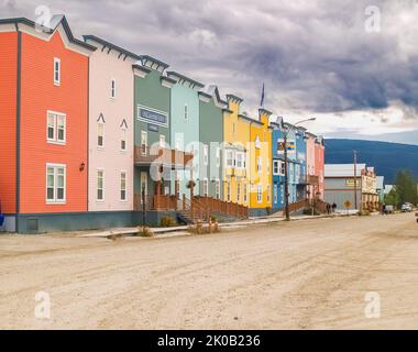 Dawson City territoire du Yukon, Canada - 5 août 2008; rangée colorée d'unités d'hébergement sur une rue poussiéreuse avec des nuages sombres au-dessus Banque D'Images