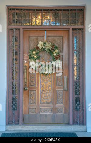 Centre-ville de Tucson, Arizona - porte sculptée avec couronne et rambardes sur la fenêtre de tableau arrière et les sidelights. Entrée extérieure avec tapis de porte à l'avant de la porte Banque D'Images