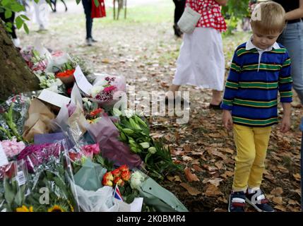 Londres, Grande-Bretagne. 10th septembre 2022. Un garçon passe devant des fleurs commémorant la Reine Elizabeth II à Green Park à Londres, en Grande-Bretagne, le 10 septembre 2022. La reine Elizabeth II, le monarque le plus ancien de l'histoire britannique, est décédée à l'âge de 96 ans, a annoncé jeudi le palais de Buckingham. Crédit : Li Ying/Xinhua/Alay Live News Banque D'Images