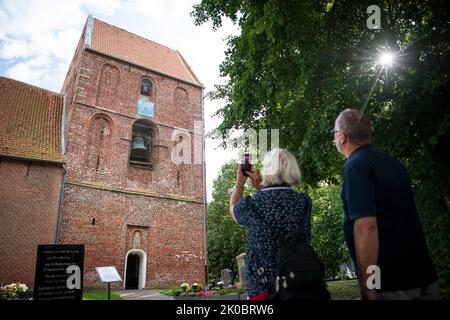 Suurhusen, Allemagne. 09th septembre 2022. Les touristes prennent des photos de la tour penchée de l'église de Suurhusen. Selon une nouvelle mesure, la 'Tour de Pise' de Gau-Weinheim en Rhénanie-Palatinat a une pente de 5,4277. Cela a brisé le record précédemment détenu par la tour de Suurhusen en Frise orientale C la tour de Suurhusen a une inclination de seulement 5,19. Credit: Sina Schuldt/dpa/Alay Live News Banque D'Images