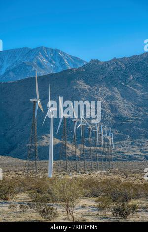 Palm Springs, Californie - Tour tubulaire en acier du moulin avec les moulins à vent sur les tours de treillis. Rangée de tubines de vent sur une terre désertique contre le Mo Banque D'Images