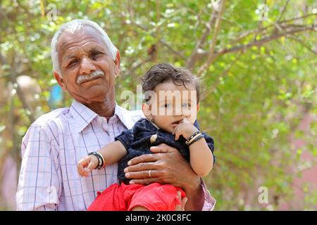 Photo portrait d'un grand-père indien senior avec un petit-fils regardant l'appareil photo avec un arrière-plan flou Banque D'Images