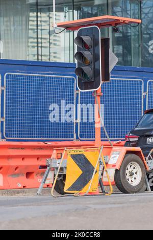 Des feux de signalisation portables à énergie solaire sont utilisés près d'un chantier de construction pour contrôler les mouvements de la circulation Banque D'Images