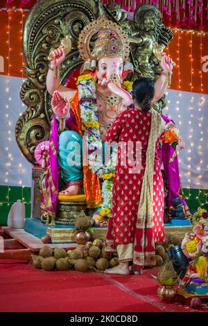 Mumbai, Inde, 05 septembre 2022 - Une femme priant devant une belle idole de Lord Ganesha à un mandal à Mumbai pour le festival de Ganesh Chaturthi Banque D'Images