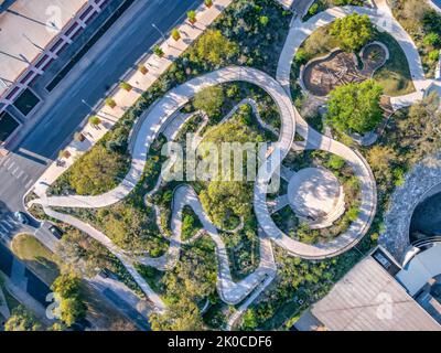 Vue aérienne du parc et des rues de Waterloo à Austin, Texas. Il y a des rues à l'extérieur du parc avec vue sur les allées incurvées en béton. Banque D'Images