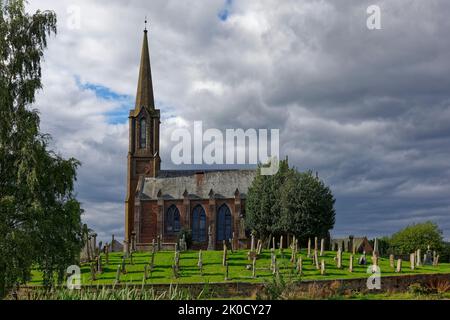 La vue latérale de l'église paroissiale de Fettercairn dans le centre du village situé sur un monticule surélevé et entouré par son cimetière ovale. Banque D'Images