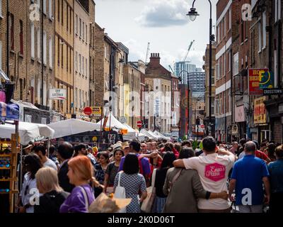 Marché animé de Brick Lane, en regardant vers la City de Londres un jour d'été Banque D'Images