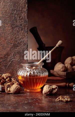 Miel et noix sur une table de cuisine ancienne. Banque D'Images