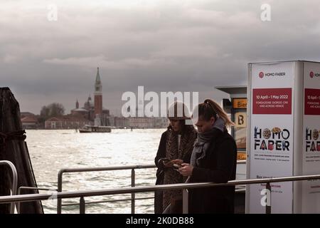 Venise, Italie - avril 21 : deux touristes dans la zone d'embarquement pour le vaporetto de Venise sur 21 avril 2022 Banque D'Images