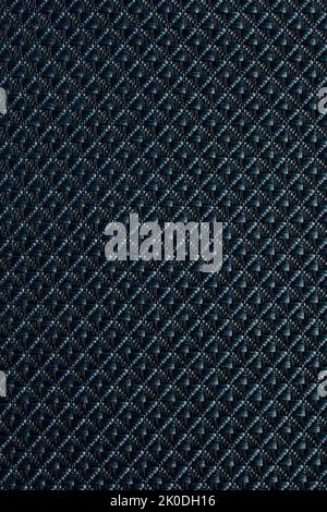 Gros plan de tissu synthétique texturé à motif losanges utilisé pour fabriquer des stores. Modèle de conception ou fond abstrait en polyester. Banque D'Images