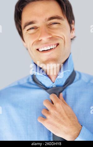 Gros plan d'un homme d'affaires heureux et réussi portant une cravate. Gros plan d'un beau jeune homme d'affaires portant une cravate , se préparer au travail. Banque D'Images