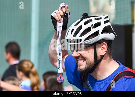 Brighton Royaume-Uni 11th septembre 2022 - Un finisseur heureux termine le tour à vélo de Londres à Brighton sur le front de mer . Le trajet est en aide à de nombreuses œuvres caritatives, y compris la Great Ormond Street Hospital ChildrenÕs Charity : Credit Simon Dack / Alamy Live News Banque D'Images