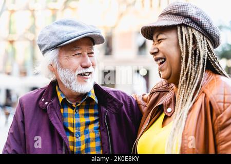 Joyeux couple multiracial senior s'amusant en ville - personnes âgées et concept de relation d'amour Banque D'Images