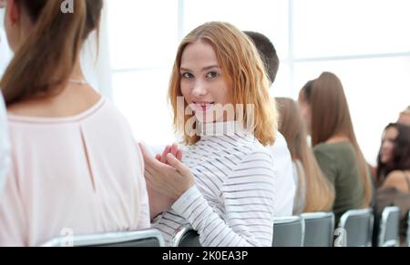 Close up. Jeune femme assise dans une rangée avec ses associés. Banque D'Images